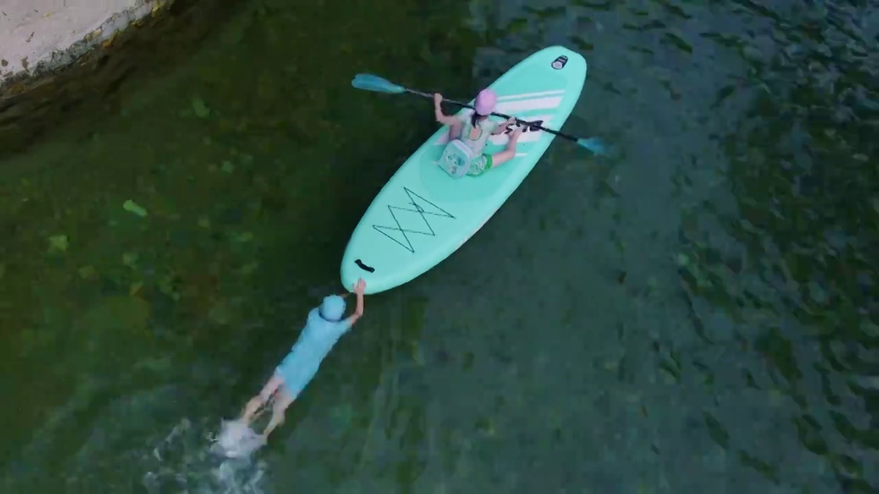 航拍清澈水上的桨板运动儿童夏季玩水航拍视频素材