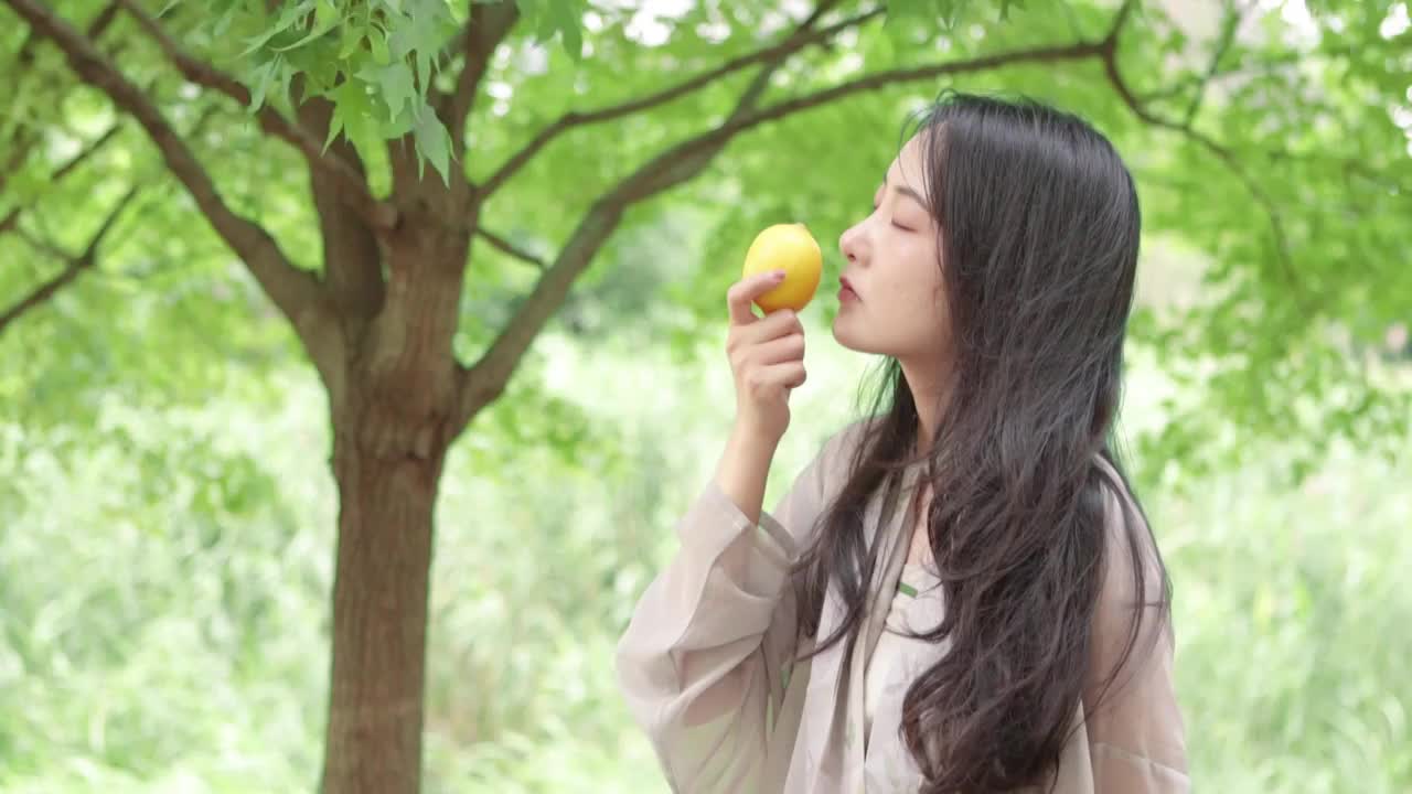 亚洲美女在树林里闻着柠檬视频下载