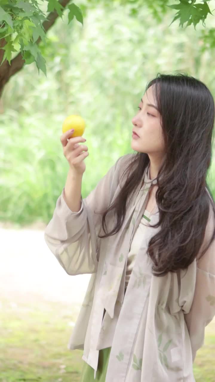 亚洲美女在树林里闻着柠檬视频下载