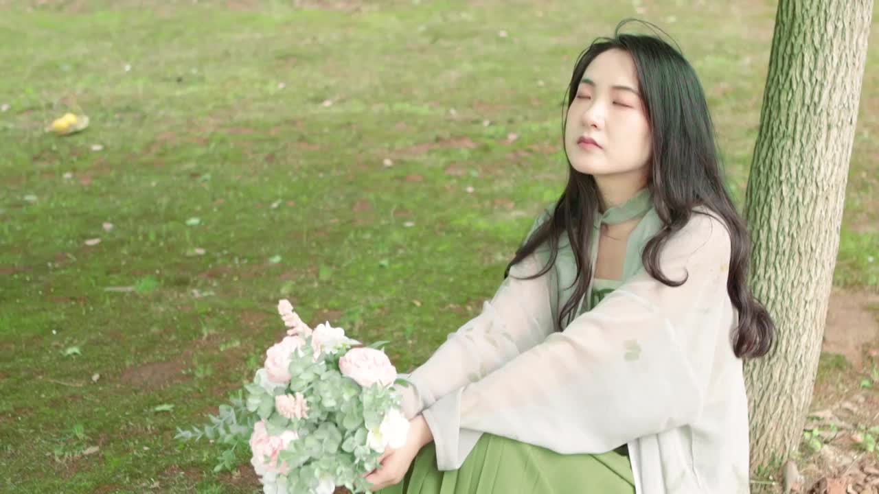 亚洲美女在公园树林里休息拿着花束视频下载