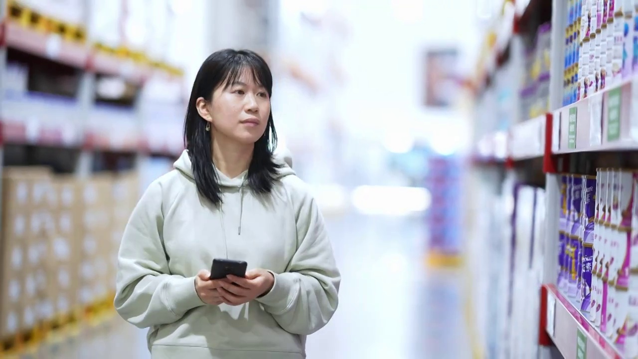 疫情期间女性拿着手机逛超市购物消费视频下载