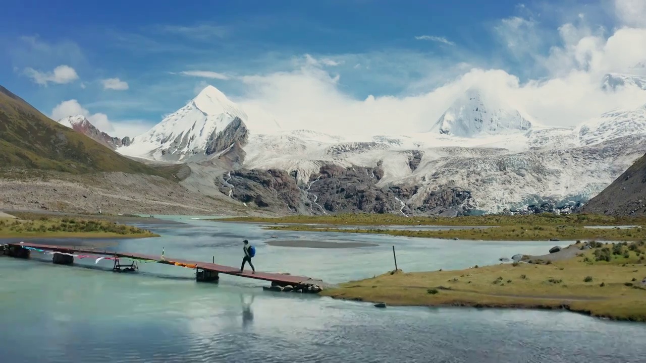 航拍背包客行走在西藏萨普神山河上的木桥上视频购买