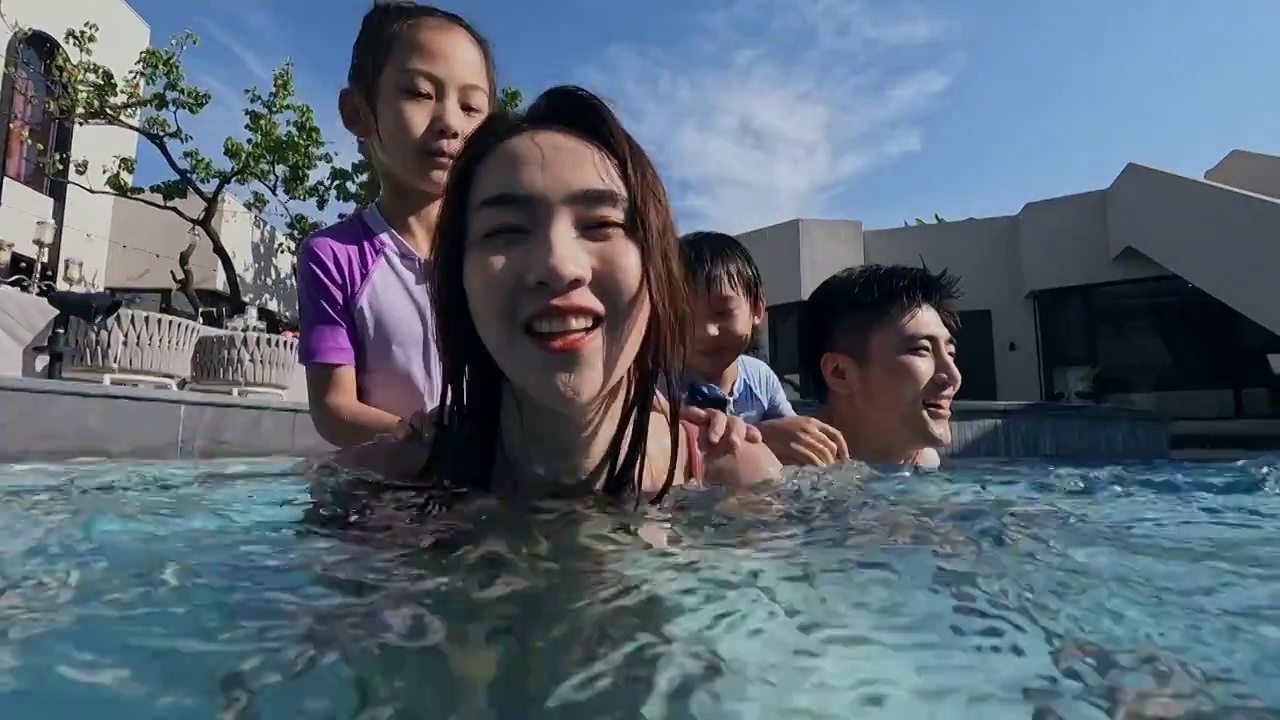快乐的一家四口在泳池里游泳视频下载