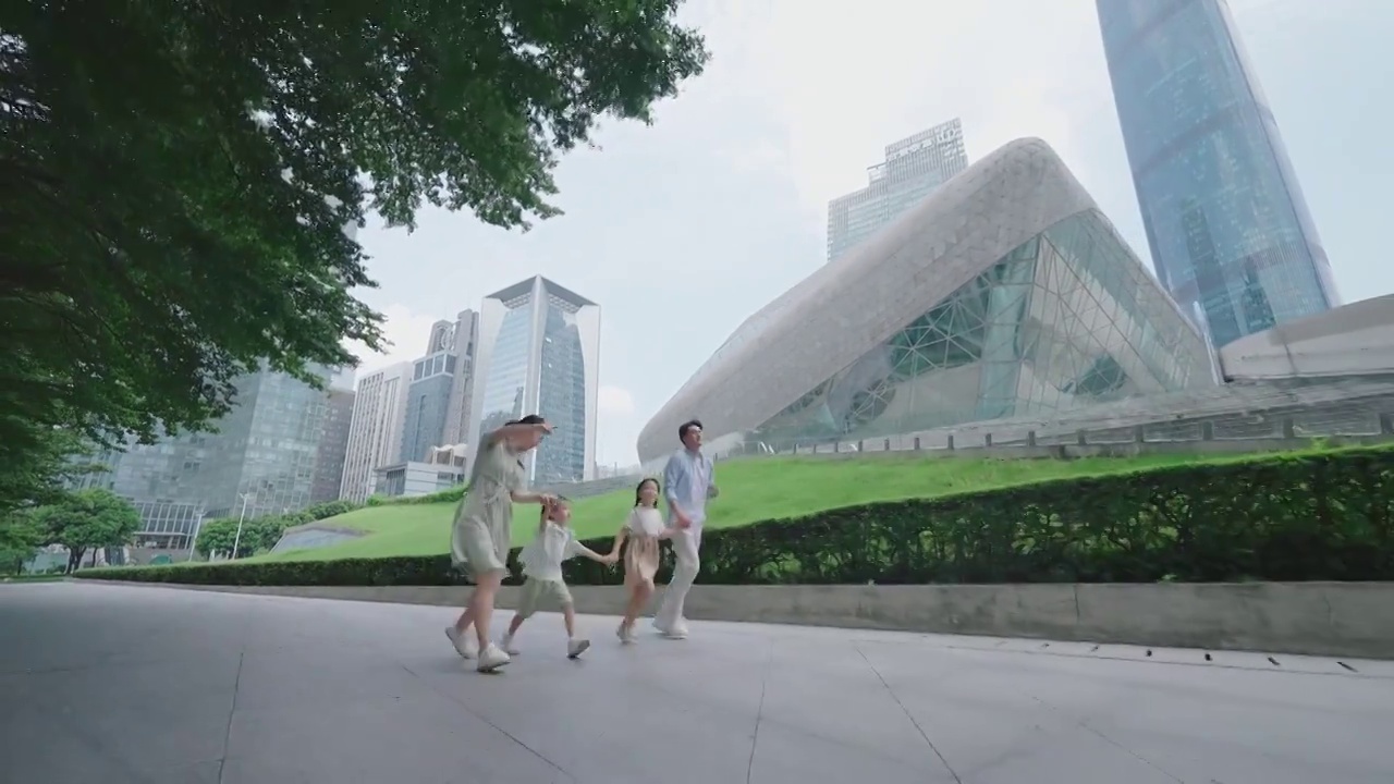 一家人手牵手奔跑在广场视频下载
