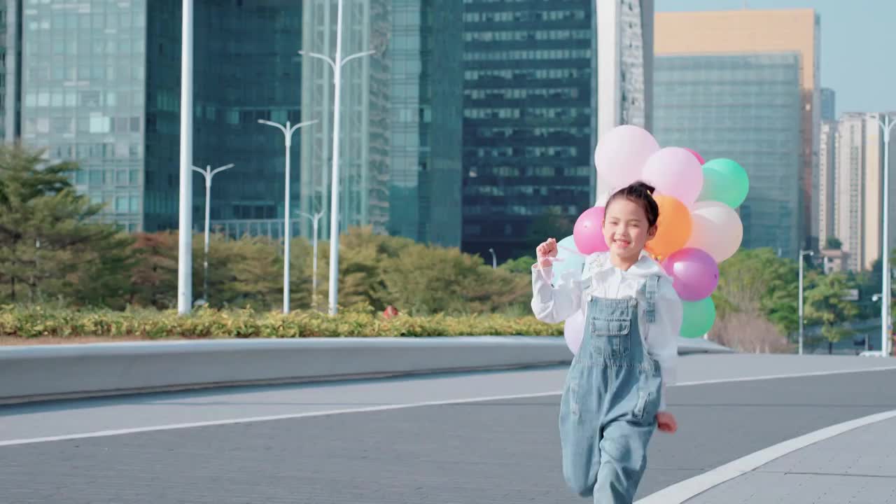 城市中奔跑的孩子手拿气球视频素材