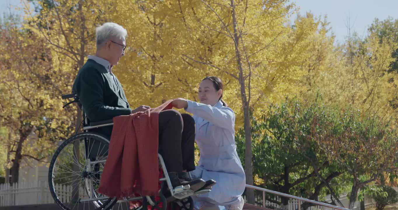年轻护工照顾坐轮椅的老年人视频素材