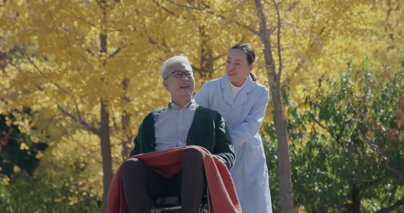 年轻护工照顾坐轮椅的老年人视频素材