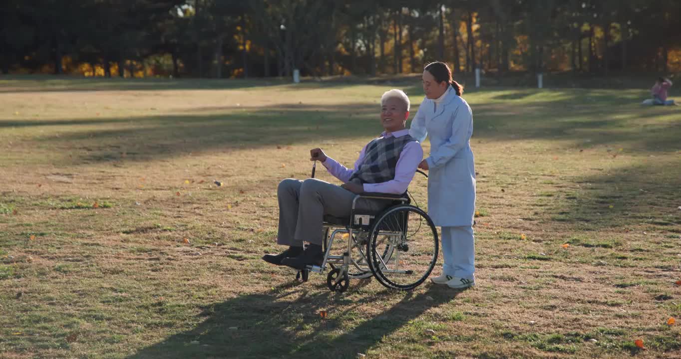 年轻护工照顾坐轮椅的老年人视频下载