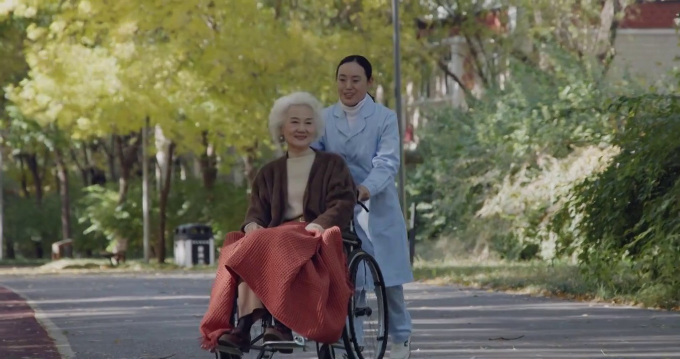年轻护工照顾坐轮椅的老年人视频下载