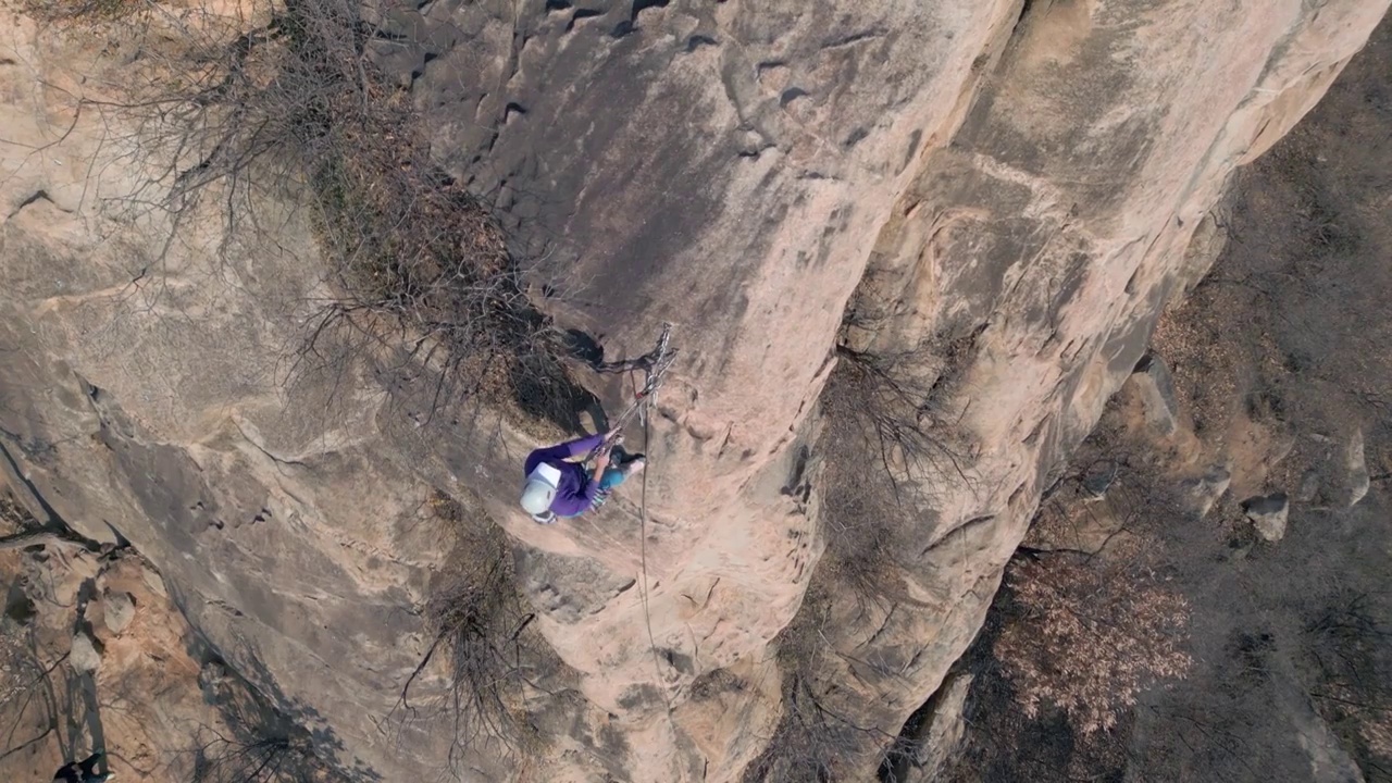 青年女人在悬崖峭壁上攀岩视频下载