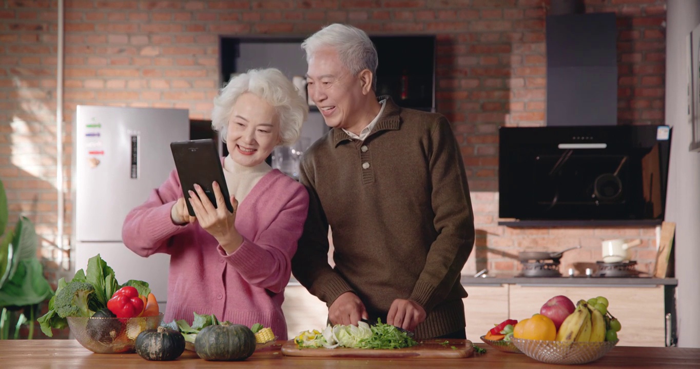 老年夫妇边看平板电脑边做饭视频下载