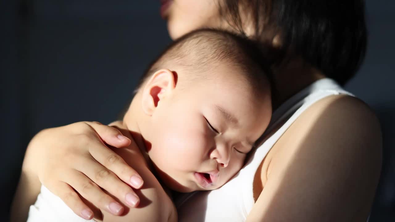 妈妈抱着宝宝轻轻拍打后背哄孩子睡觉视频下载