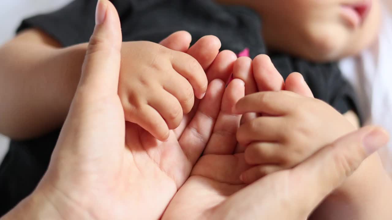 妈妈双手握着睡觉的宝宝的小手按摩视频下载