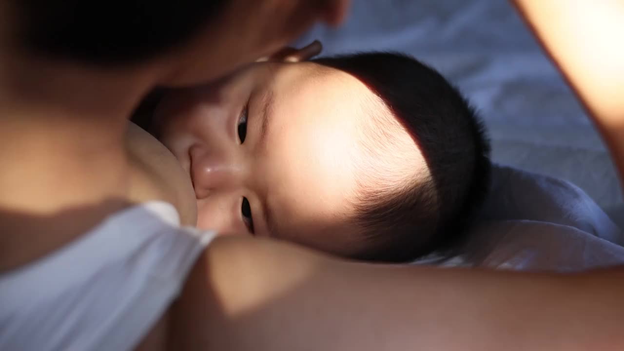 阳光下哺乳期母亲喂宝宝吃奶视频下载