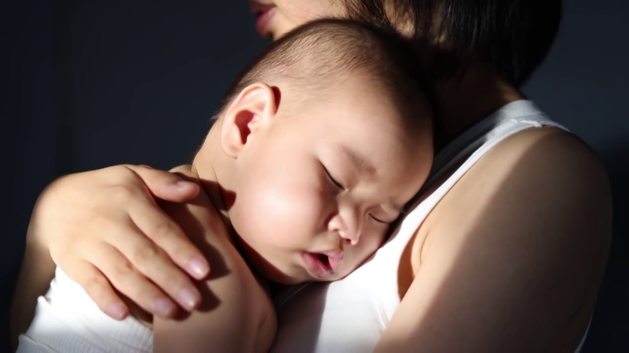 妈妈抱着宝宝轻轻拍打后背哄孩子睡觉视频下载