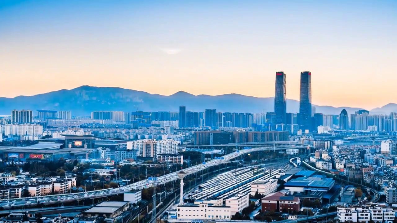 中国云南昆明双子塔和高架桥车流城市天际线日转夜延时摄影视频素材