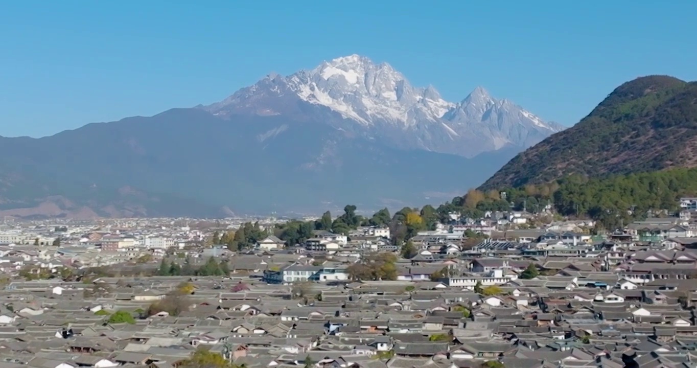 航拍空中鸟瞰云南玉龙雪山下的丽江古城风景视频素材