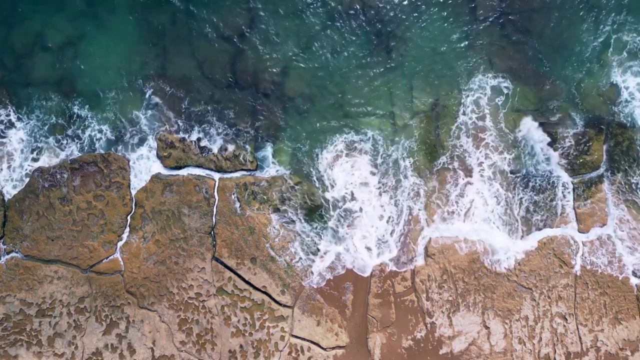三亚海边空中俯拍海浪拍打在礁石上视频下载