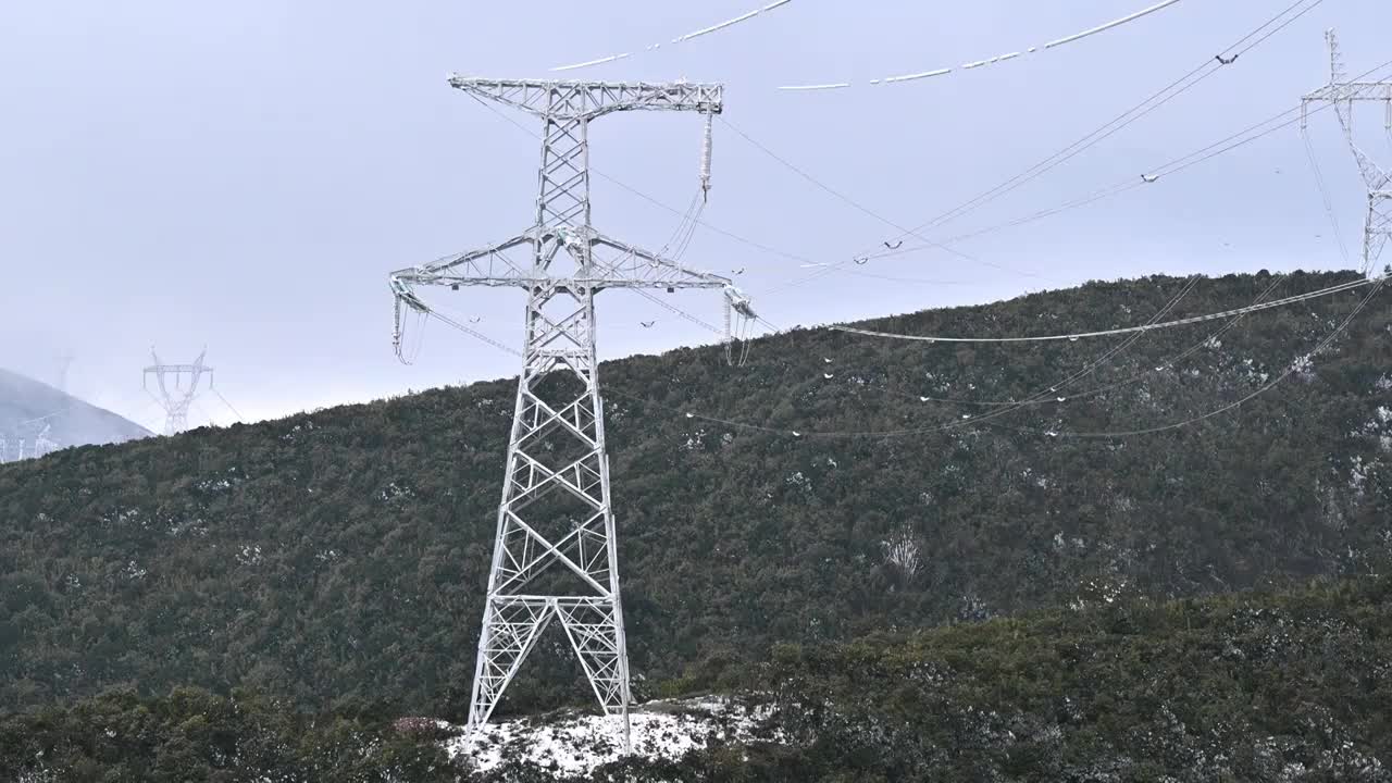高原冬季输电线高压铁塔电缆冰雪冰块融化下落视频下载