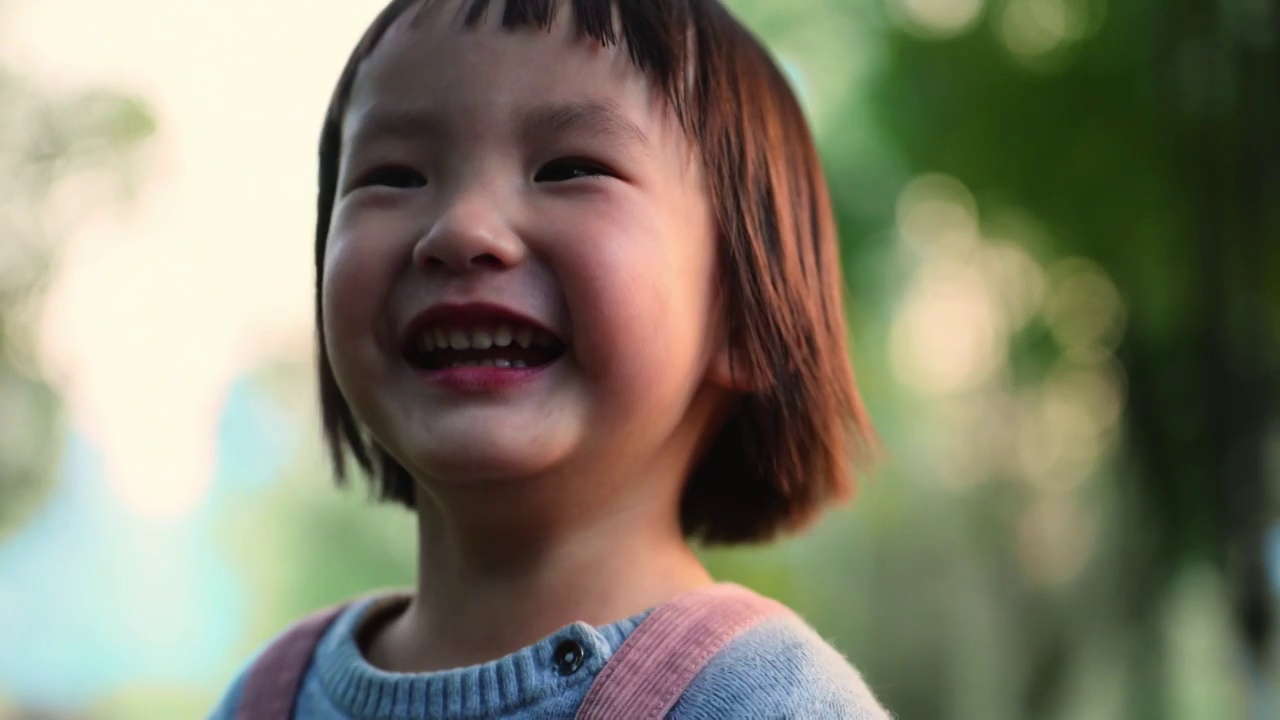 可爱小女孩公园里开心微笑特写镜头视频下载