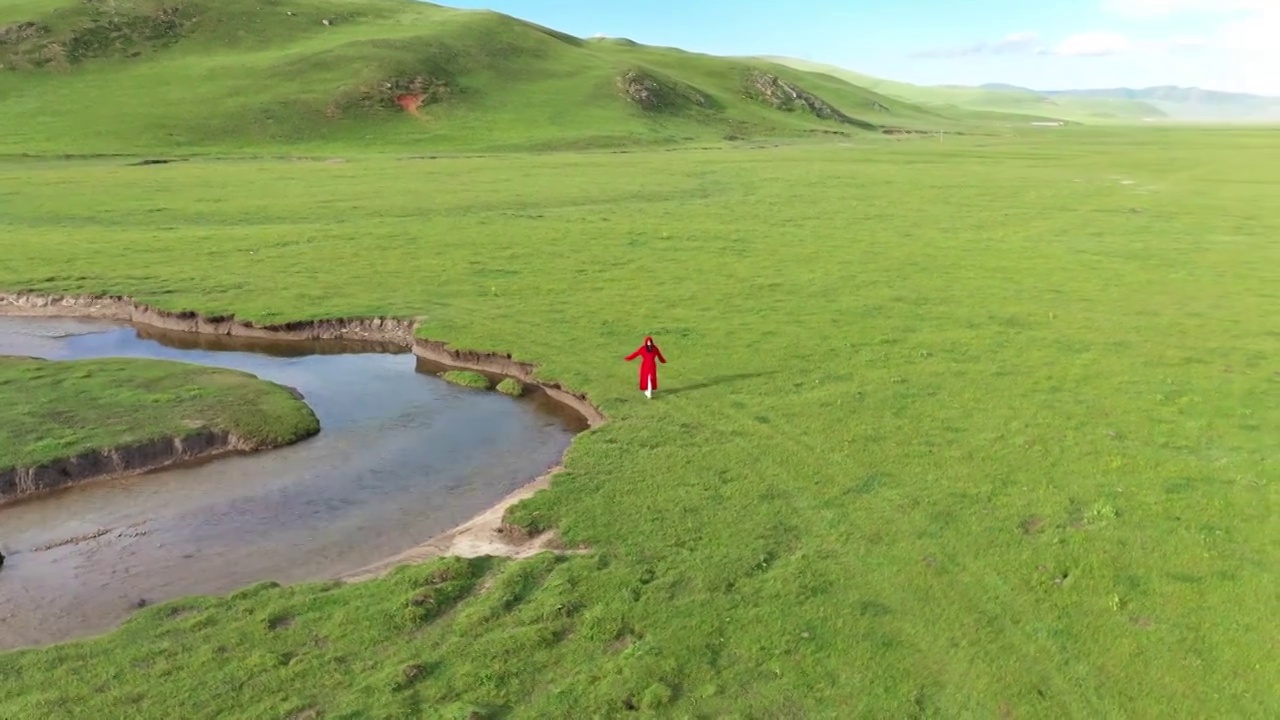 航拍空中鸟瞰红衣少女在草原河边散步视频下载