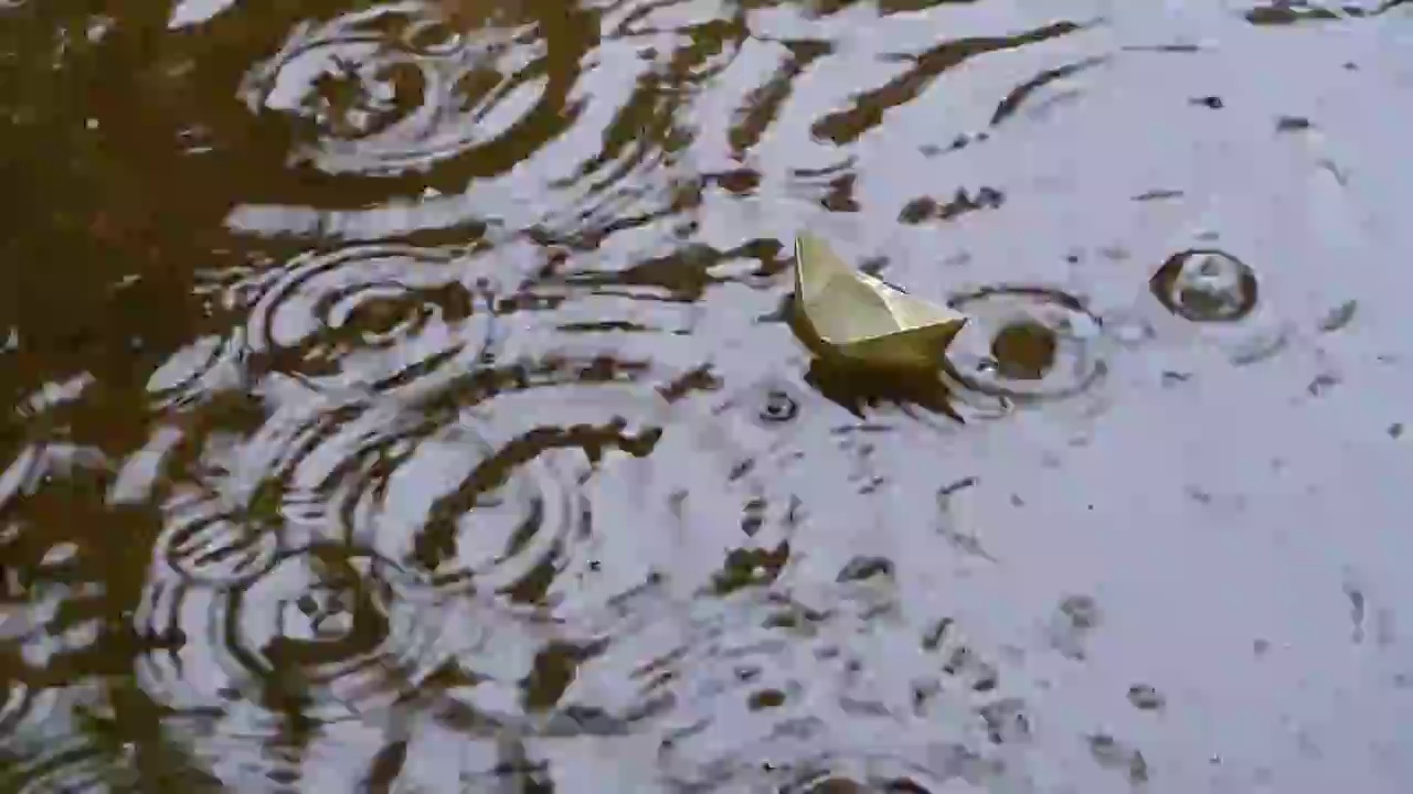 小雨中漂浮的纸帆船视频下载