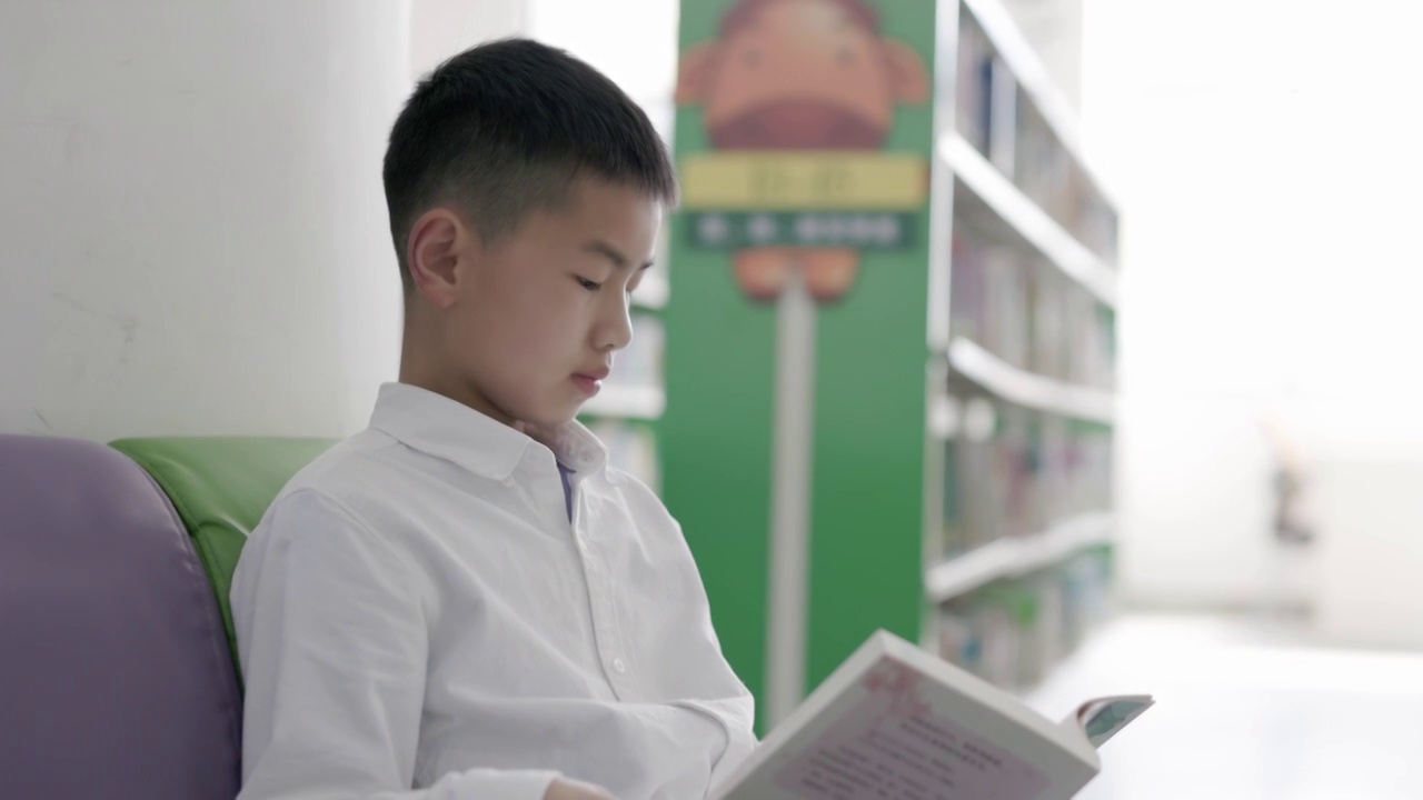 4K一个小学生在图书馆看书视频素材