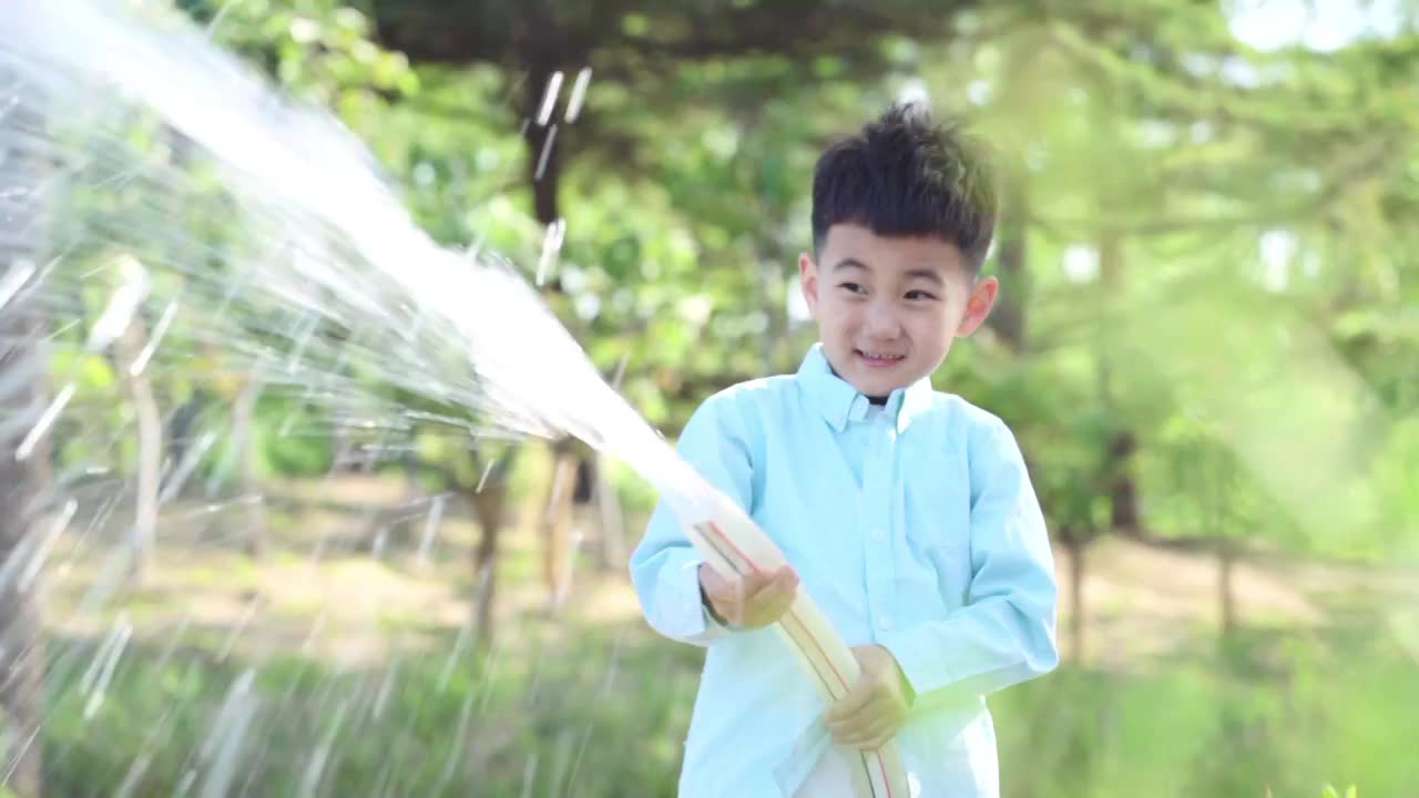 在公园里浇水的快乐男孩视频购买