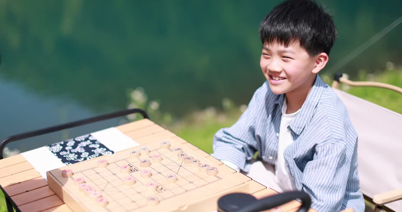 正在湖边下棋的中国小男孩视频素材