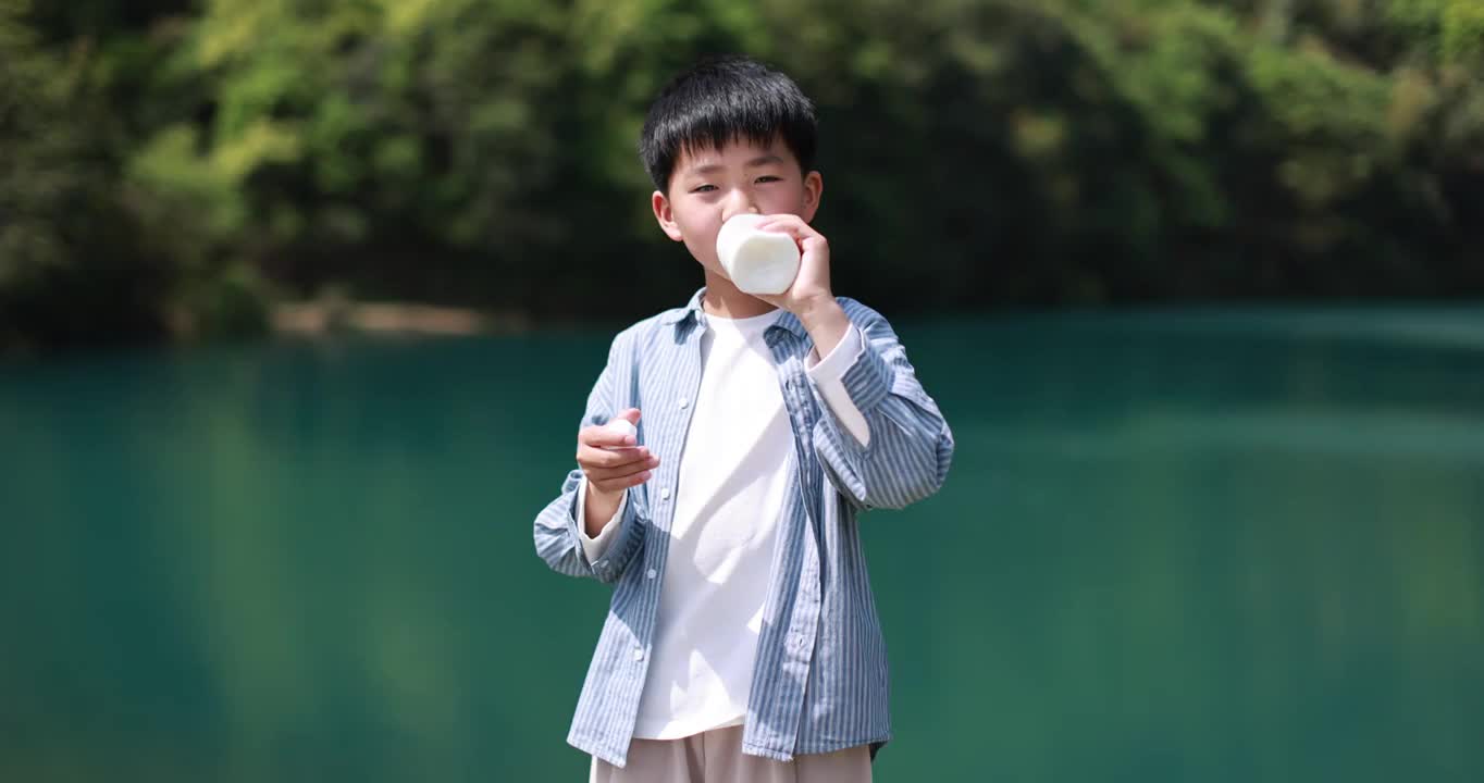 中国小男孩在户外喝有机牛奶升格慢动作视频素材