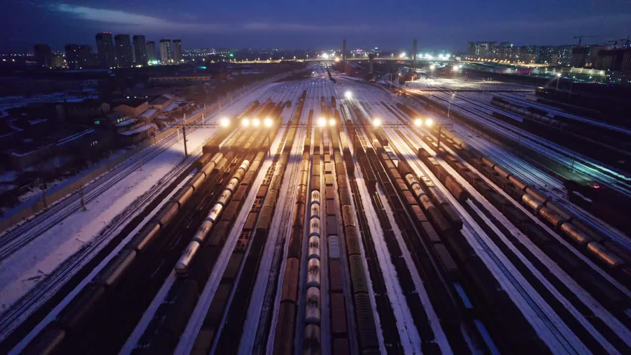 中国哈尔滨南站冬季货运火车夜景航拍视频下载
