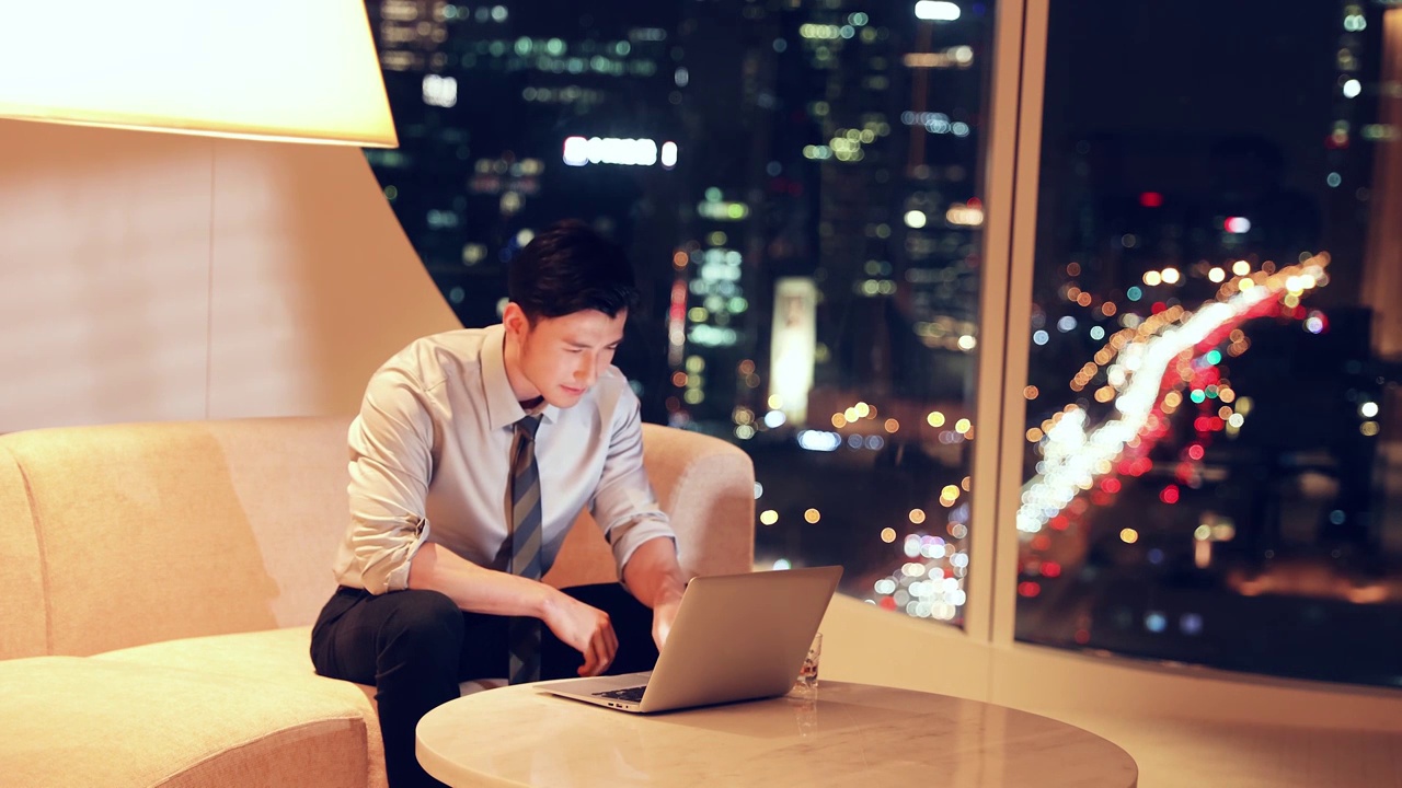 夜晚商务男子在酒店房间使用笔记本电脑视频通话工作视频下载