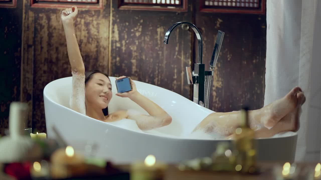 快乐的女人在户内边泡澡边自拍视频下载