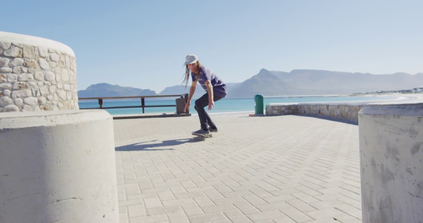 留着脏辫的白人男子在阳光明媚的海滨散步道上玩滑板的视频视频下载