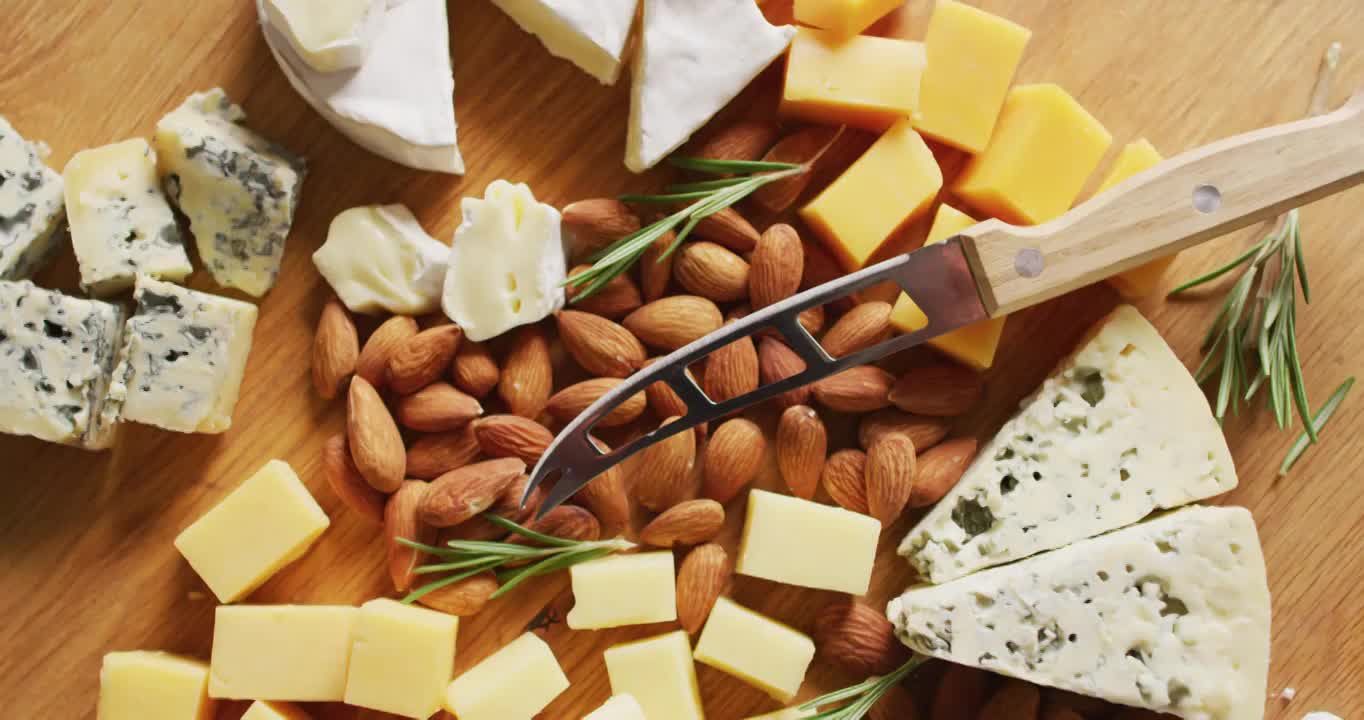 视频的混合硬和软奶酪，坚果和迷迭香与刀在木板上视频下载