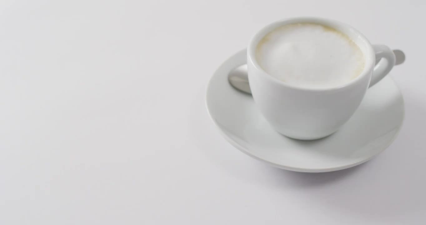 视频白色的咖啡杯与牛奶在白色的背景视频下载
