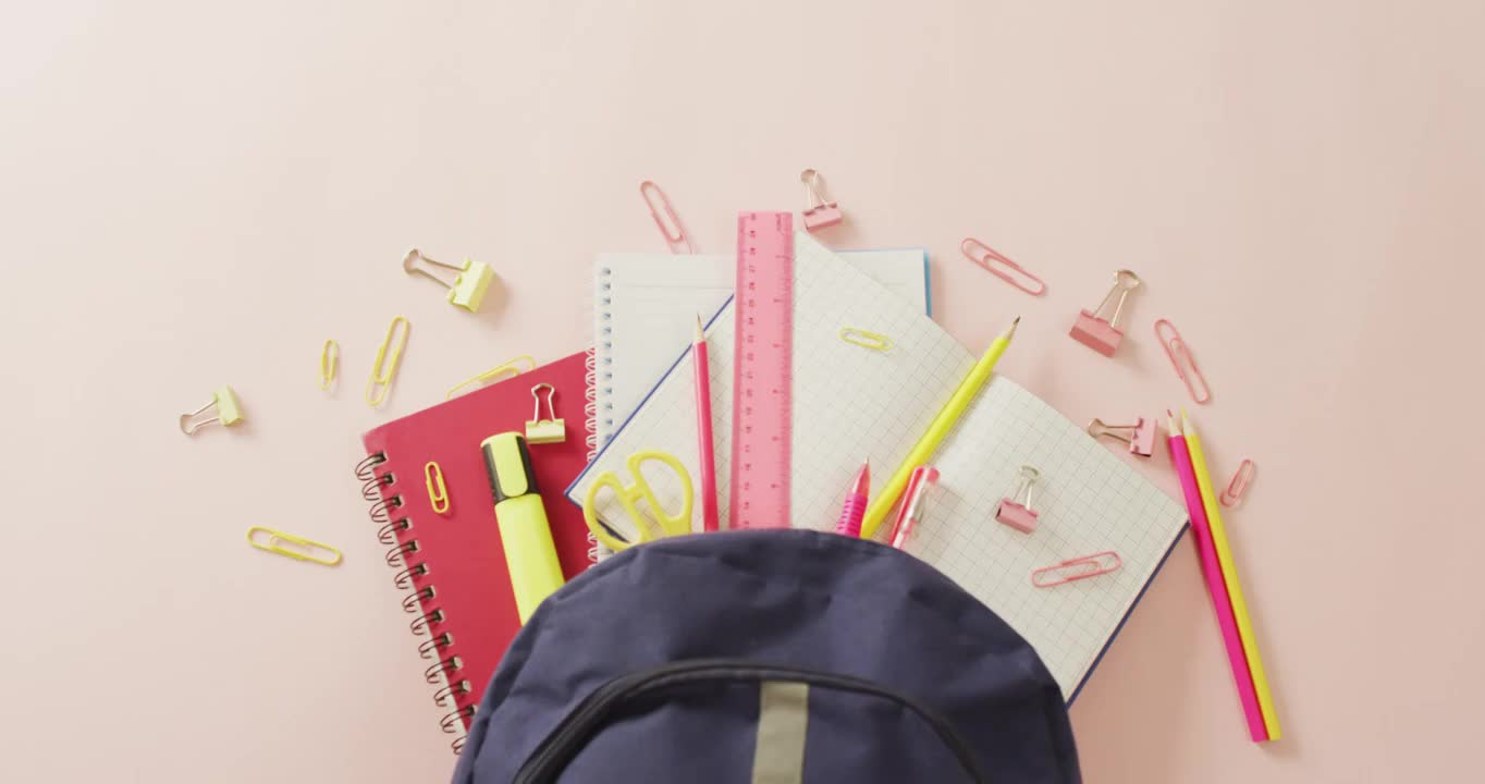 视频与学校用品在浅粉红色的表面背包视频下载