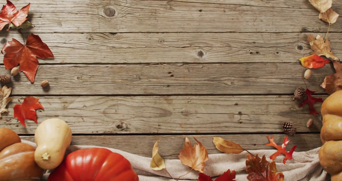 视频南瓜与松果和秋天的树叶在木制背景视频素材