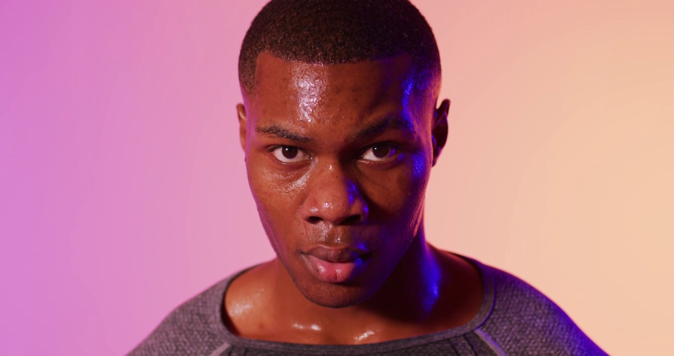 非裔美国男性跑步者的肖像，在粉红色的灯光下穿着运动服视频下载