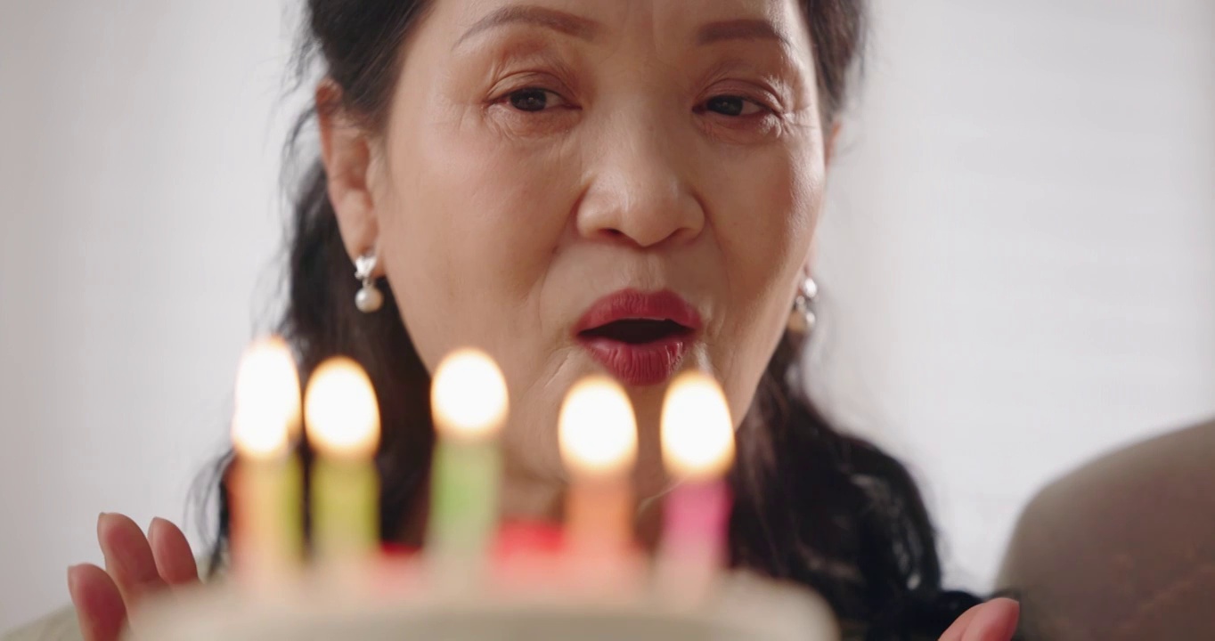 幸福的老年女人许愿吹蜡烛视频下载