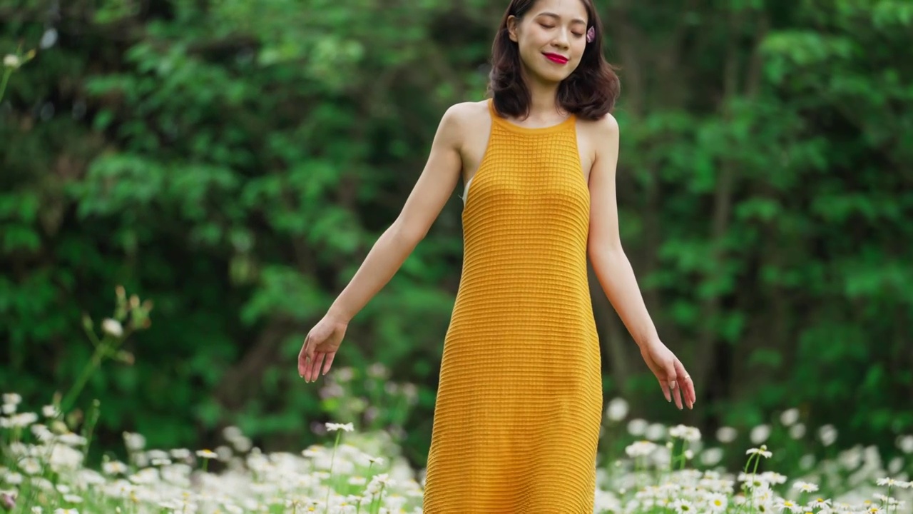 穿黄短裙身材苗条美女走鲜花草地的婀娜身姿视频下载
