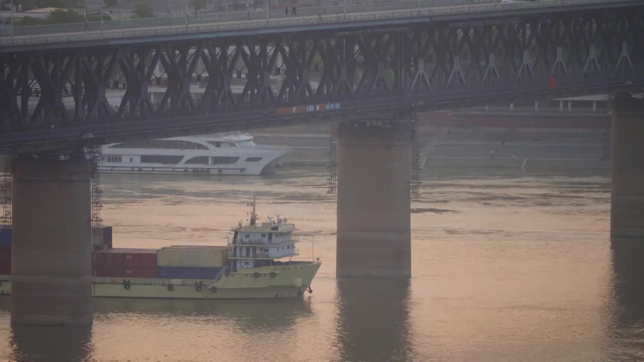 武汉市长江大桥下清晨日出通过的运输船视频下载