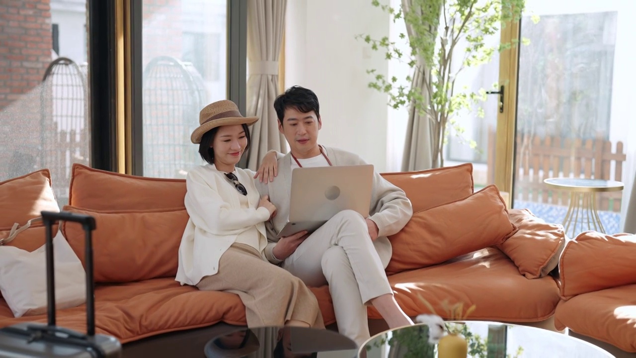 快乐的年轻夫妇使用笔记本电脑视频下载