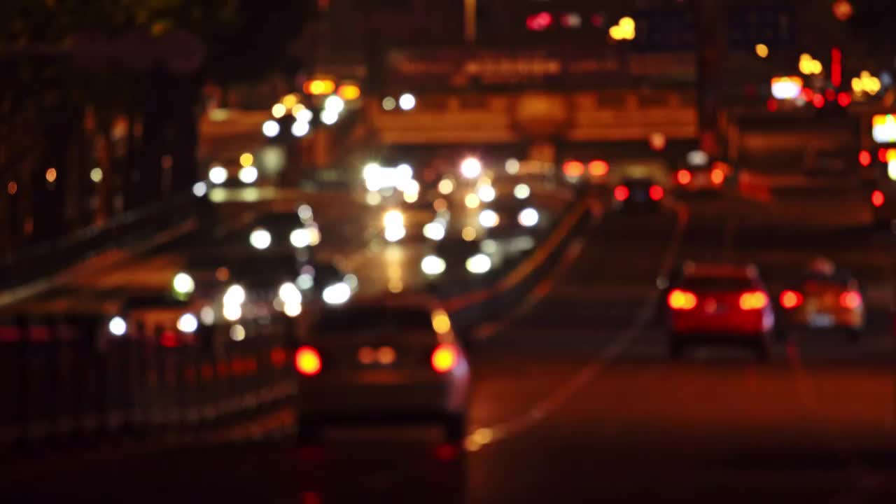 中国哈尔滨夜晚城市道路汽车交通虚化光斑视频下载