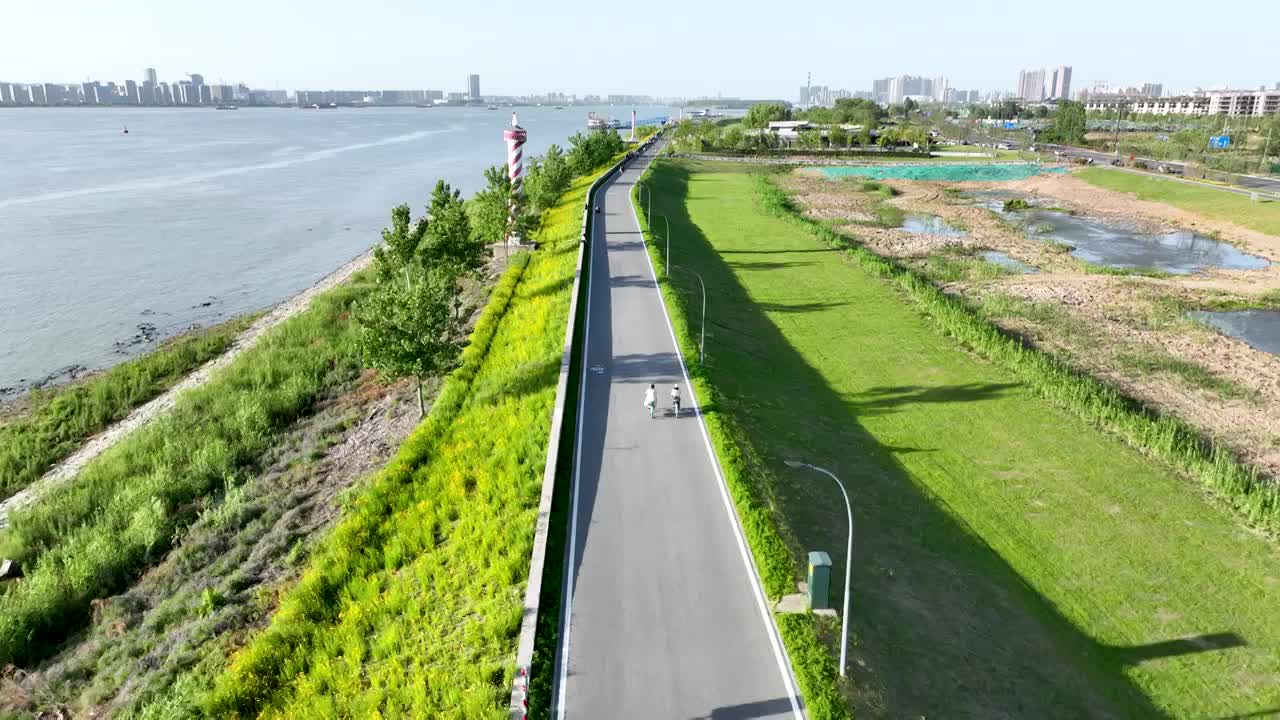 游客在长江边环岛路上骑行踏青休闲视频下载
