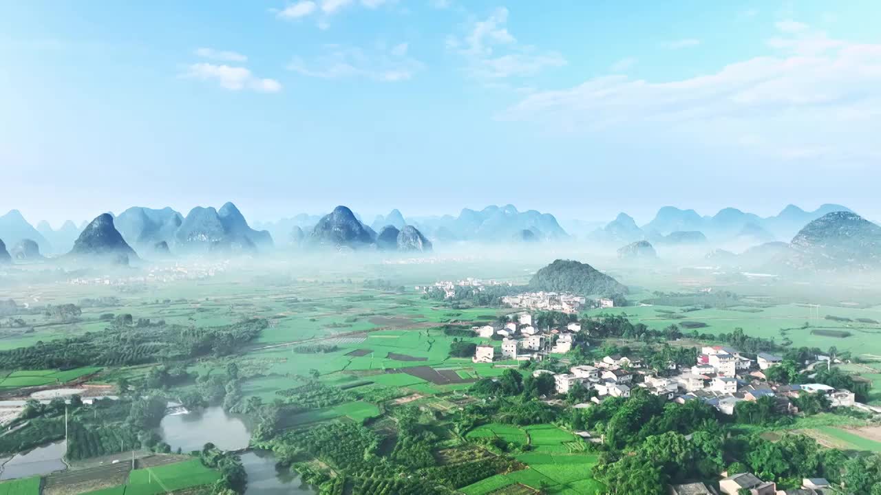 夏天的早晨桂林喀斯特地貌山间的村庄和稻田上漂浮着一层薄雾视频下载
