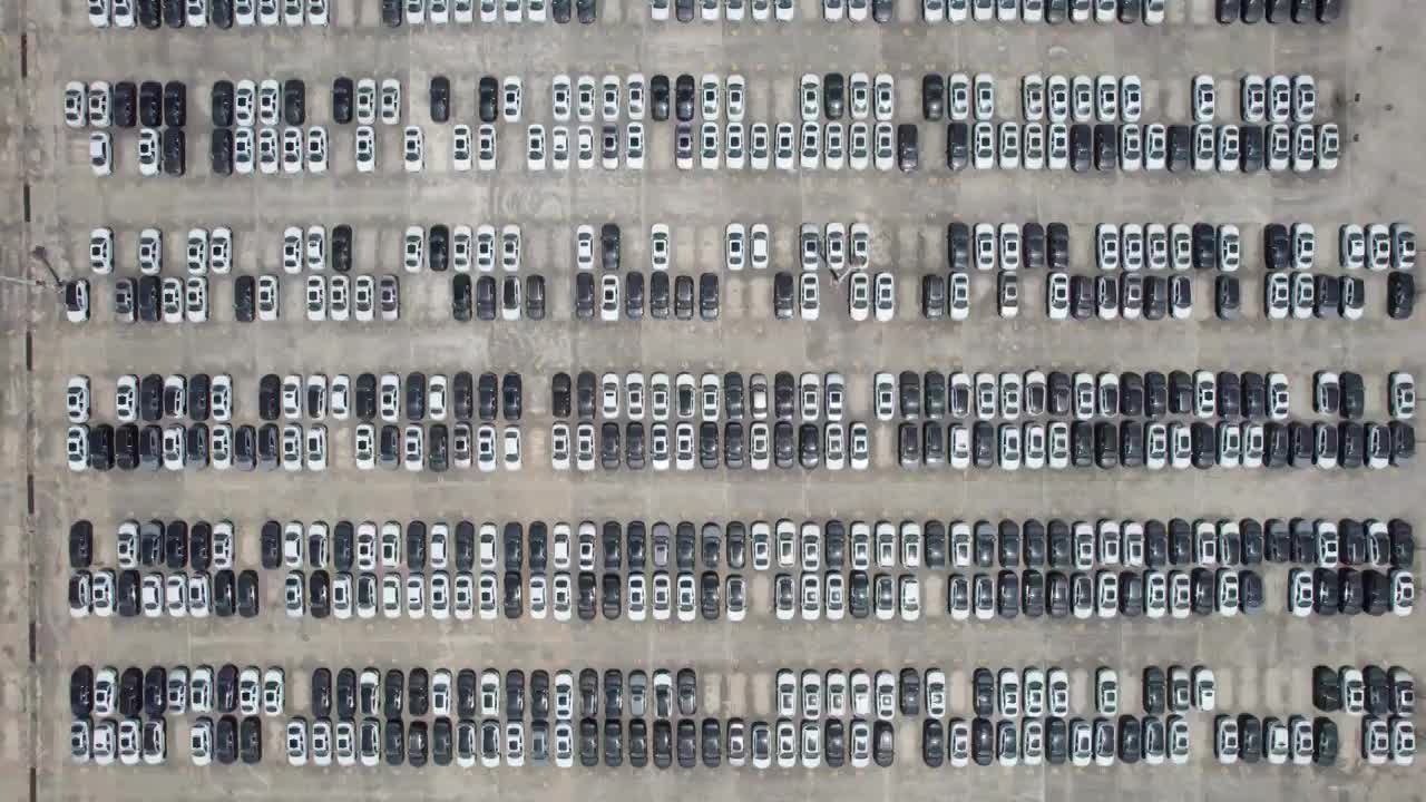 成都龙泉驿汽车产业园，新造好的汽车整齐的停放在停车场白昼晴天航拍镜头视频下载