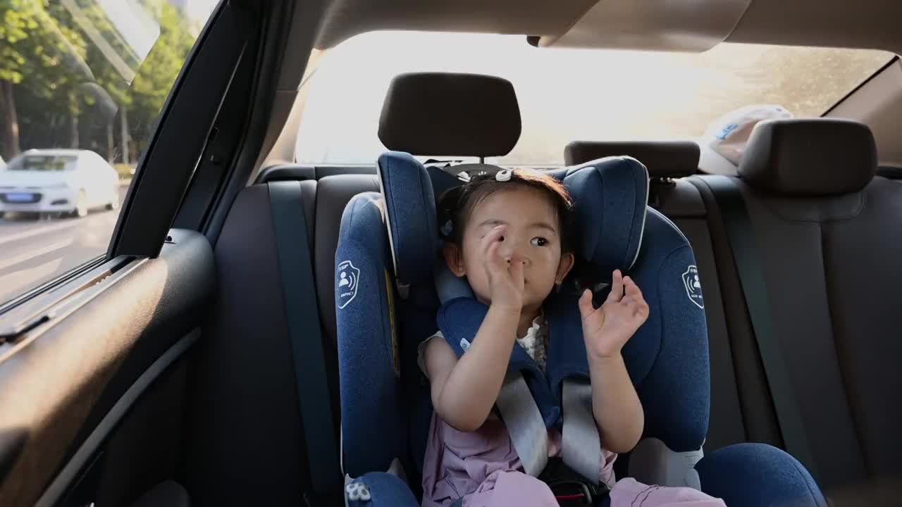 一个坐在汽车儿童安全座椅上的小女孩视频下载