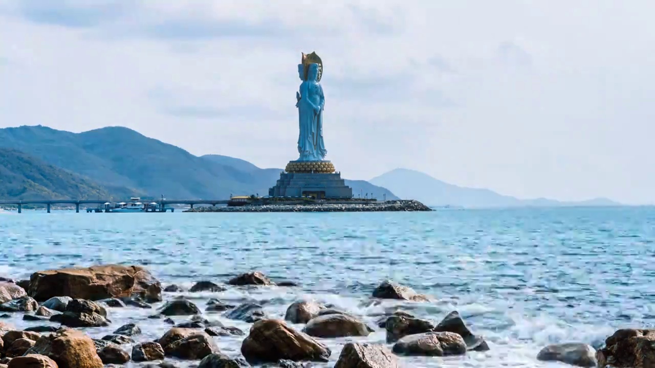 中国海南三亚南山文化旅游区海上观音雕像和海边礁石延时摄影视频下载