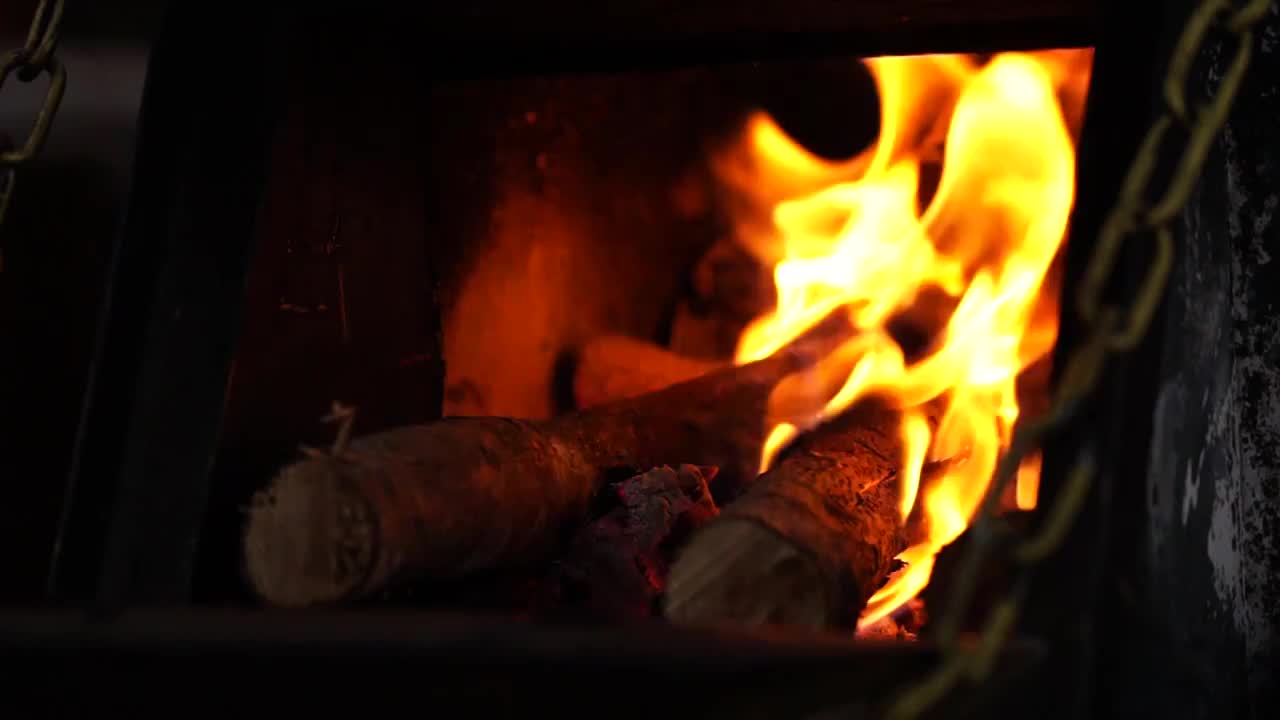 木柴在炉中燃烧产生火光的慢镜视频下载